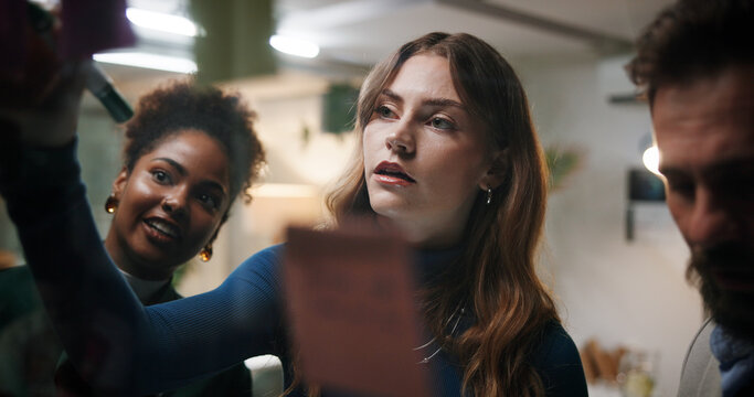 Brainstorming, team and writing of ideas, office and colleagues with marketing strategy, planning and night. Business meeting, overtime and people with sticky notes for collaboration and working late