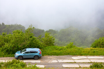 perechyn, ukraine - 22 ju2 2019: 4wd car on a countryside mountain road. reliable 4wd suv for a journey on the edge of a hill. explore highland of ukraine on a misty forenoon in summer