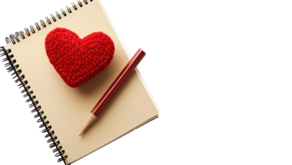 A red felt heart rests on a tan spiral notebook alongside a burgundy pencil, set against a black background