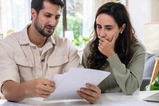 Couple overwhelmed by overdue bills and low income, facing economic stress and inflation-related financial crisis