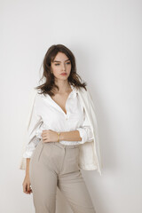  Elegant Woman in White Blazer, Shirt, and Beige Pants Posing Stylishly 