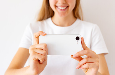 Girl holding phone in hands and taking photo or recording video