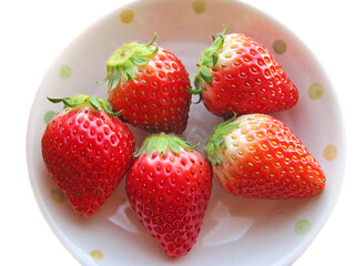Multiple hefty strawberries on a white plate