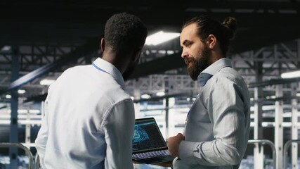 Data center workers cooperating, doing maintenance on rigs handling AI processing tasks. Server hub admins doing brainstorming, managing storage arrays supporting deep learning technology, camera B - Powered by Adobe