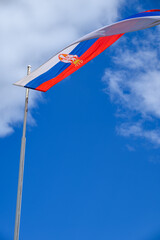 Huge Flag of Serbia flapping in the wind on a flagpole