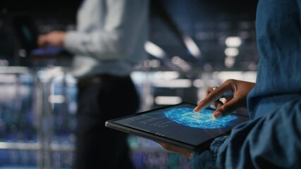 Close up of data center engineer using tablet, doing maintenance on rigs handling AI processing tasks. Server hub computer scientist managing storage arrays supporting deep learning tech, camera A - Powered by Adobe