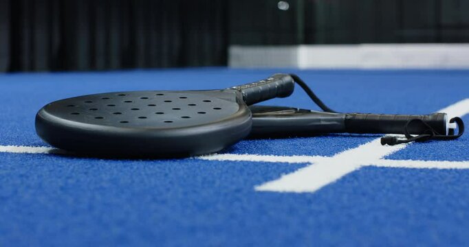 Padel racket resting on blue court, ready for exciting match, copy space