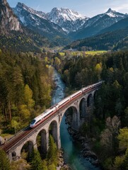 Obraz premium A high-speed train travels over a historic stone bridge, winding through a lush green valley with mountains in the background during a sunny day