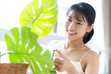 観葉植物に水をやる若い女性