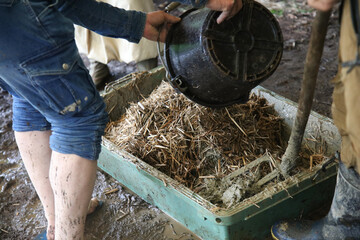 足で踏んで荒壁土を作る様子