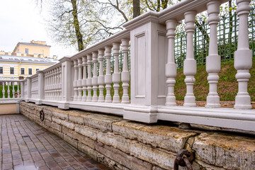A long white stone fence with balusters on the balustrade.