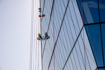 Obraz premium Mountain climbers wash windows in high-rise buildings.