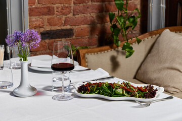 Fresh salad and red wine served at a cozy dining table