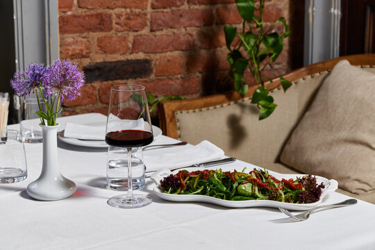 Fresh salad and red wine served at a cozy dining table