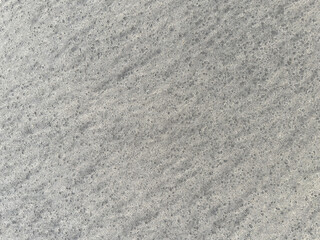 Detailed closeup of sandy beach grains showcasing texture near the ocean shore