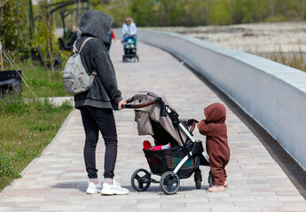 Obraz premium A woman is pushing a stroller with a child in it