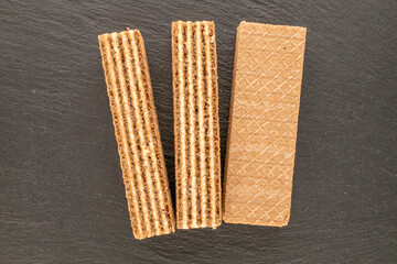 Several sweet waffles, macro, on slate stone, top view.