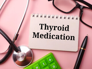 Notebook and doctor's equipment with the word Thyroid Medication on a pink background
