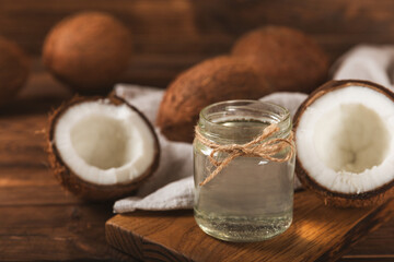 Jar of coconut oil. Coconut oil on a wooden background. Product for beauty procedures, skin and body care. Spa concept. Natural cosmetics. Space for text. Copy space.