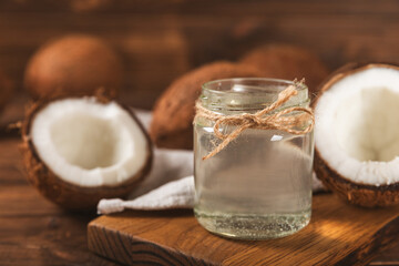 Jar of coconut oil. Coconut oil on a wooden background. Product for beauty procedures, skin and body care. Spa concept. Natural cosmetics. Space for text. Copy space.