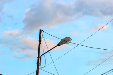 Portrait of towers, streetlights, and power poles with conduit cables on an isolated blue sky...