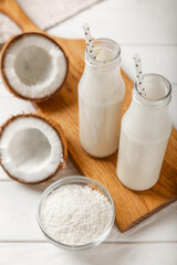 Set of fresh whole and half coconuts and slices on wooden background. Coconut flakes. Vegan. Tropical nut, fruit. Place for text. Copy space.