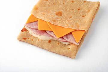 Fast food: pancake with ham, cheese and cheese sauce on white background. Serving for bar, menu.