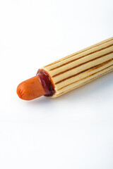 Fast food: French hot dog on a white background. Bun with ketchup and sausage