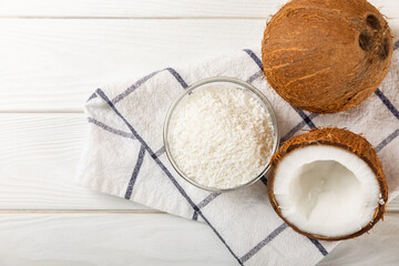 Set of fresh whole and half coconuts and slices on wooden background. Coconut flakes. Vegan. Tropical nut, fruit. Place for text. Copy space.