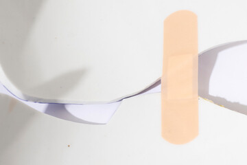 Conceptual image of fixing broken surface with band aid plaster