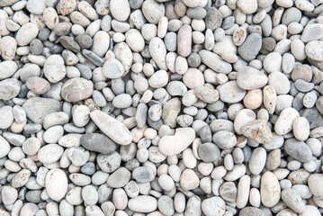 beautiful white and gray pebbles on a beach forming a background