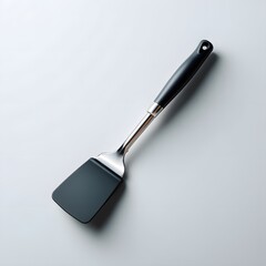a black spatula resting against a white background.
