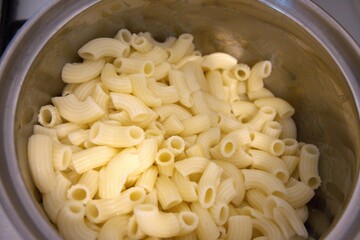 Cooked pasta in cooking pan close up.