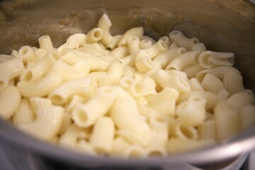 Cooked pasta in cooking pan close up.