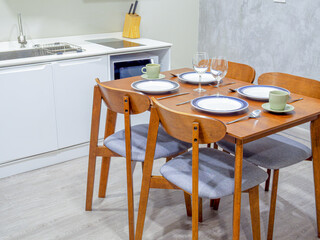 Creative composition of dining room interior with kitchen space, kitchen ware, table, chair, glass and personal accessories. Home decor. Template, clear ground and wallpaper.