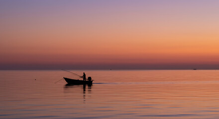 Serene Sunset Silhouette Fisherman in Small Boat at Sea Peaceful Waters