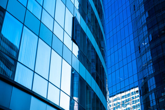 Glass facade reflecting contemporary architecture in Polanco, Ciudad de M&eacute;xico, blue tones, minimalist details, sunlight, and geometry