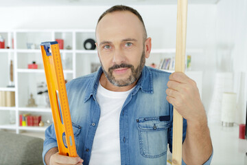 closeup of man using level on wood board