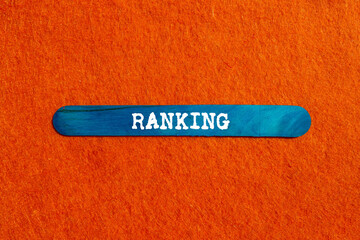 Ranking message written on blue wooden stick on orange background. Conceptual ranking symbol. Copy...