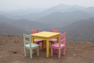 Whimsical pastel picnic set poised on a misty mountaintop, evoking Earth Day serenity and whimsical Dia de Muertos introspection