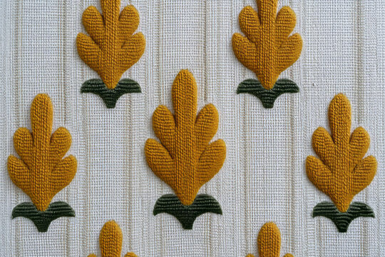 Yellow knitted oak leaves on textured fabric evoke autumnal tapestry, perfect for crafting, Samhain celebrations, and cozy hygge vibes