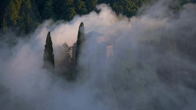 Low clouds drifting over sassovivo abbey, historic monastery nestled in umbrian countryside near foligno, generating mystical landscape with ethereal mood