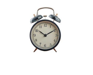 A classic alarm clock sitting on a small wooden table, isolated on a pure white background. The clock is metallic, with twin bells on top, and the time is visible on its face