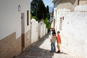 Mother and son exploring picturesque alley in granada, spain