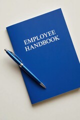 Employee handbook and pen placed on a clean surface in an office setting with a professional atmosphere