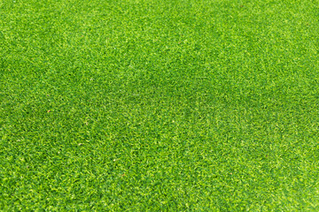 Obraz premium Close-up of lush green artificial grass, showcasing its detailed texture and vibrant color, perfect for outdoor landscaping and sports fields.