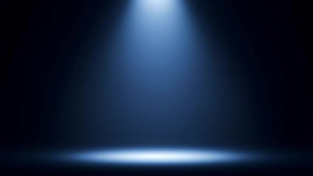 Single blue spotlight shining down onto a dark stage or floor, creating a focused, dramatic effect.