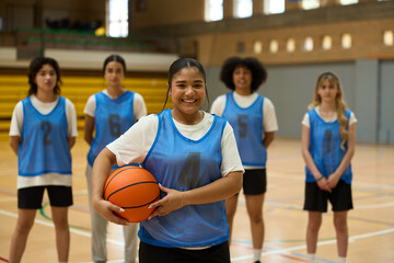 Young basketball player smiling with teammates in background