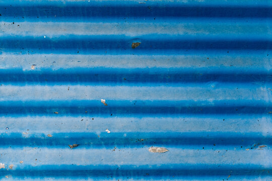 Blue corrugated metal roofing showing signs of wear and tear