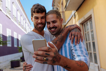 Happy gay couple taking a photo of themselves on vacation